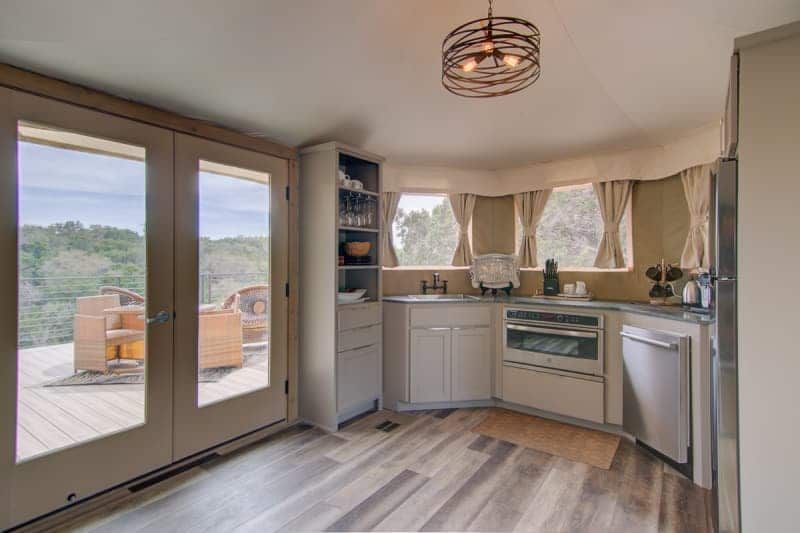 A kitchen with a lot of windows and wooden floors.