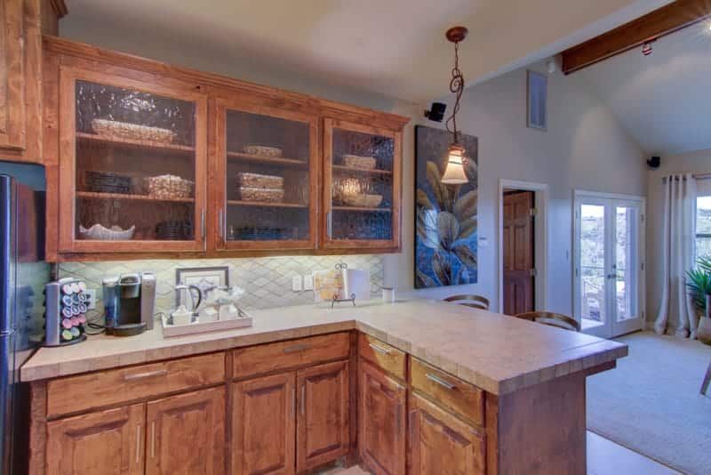 A kitchen with wooden cabinets , granite counter tops , and a large island.