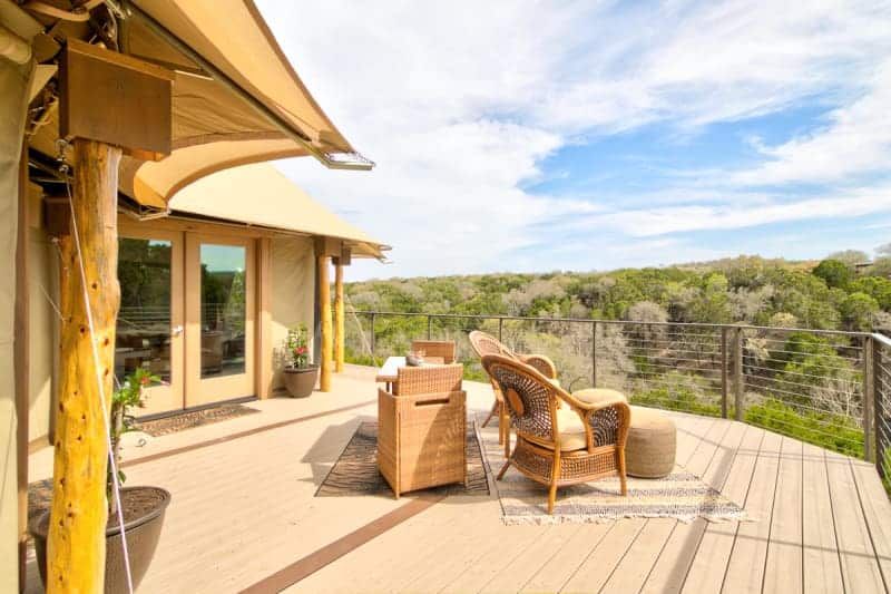 There is a large deck with chairs and a grill on it.