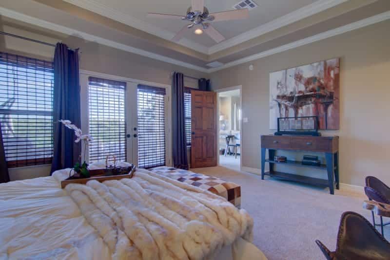 A bedroom with a bed and a ceiling fan.
