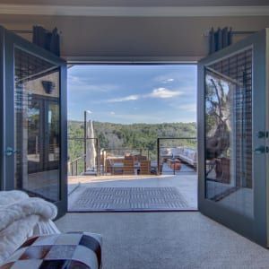 A living room with a view of a balcony and a chair.