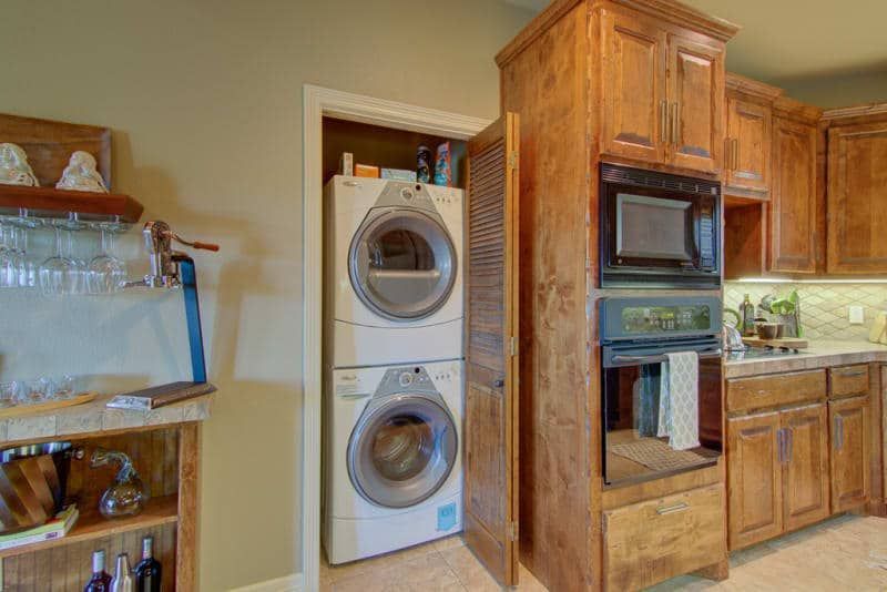 A kitchen with a washer and dryer stacked on top of each other.