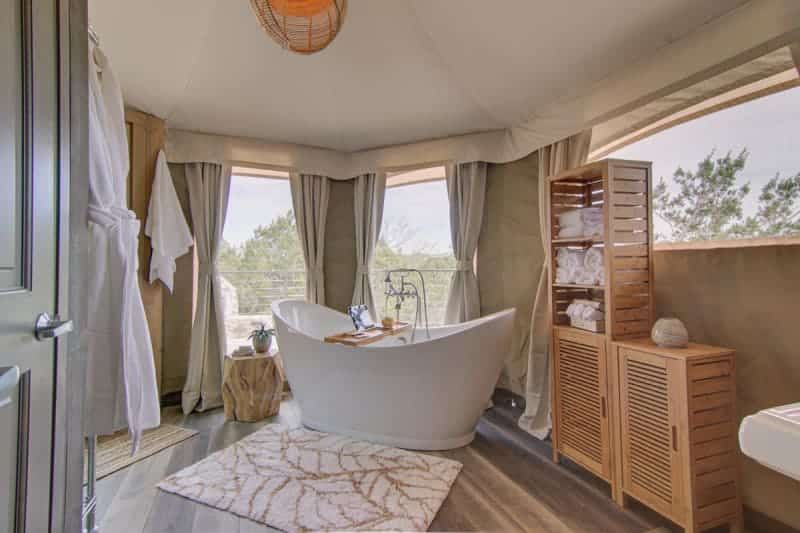 A bathroom with a tub and a window.