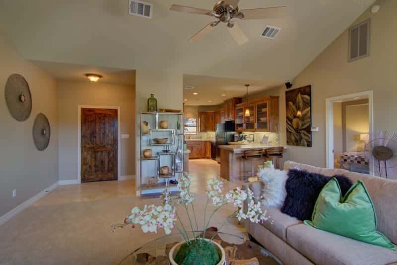 A living room with a couch , coffee table , and ceiling fan.