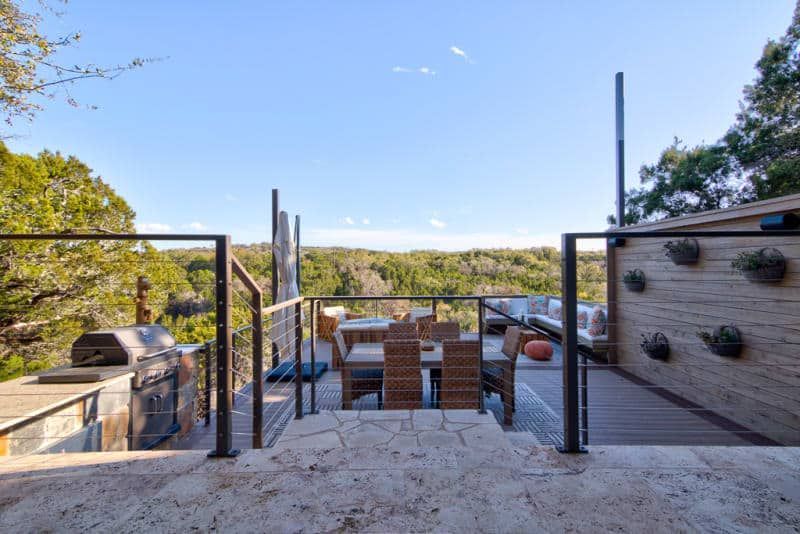 A patio with a table and chairs and a grill.