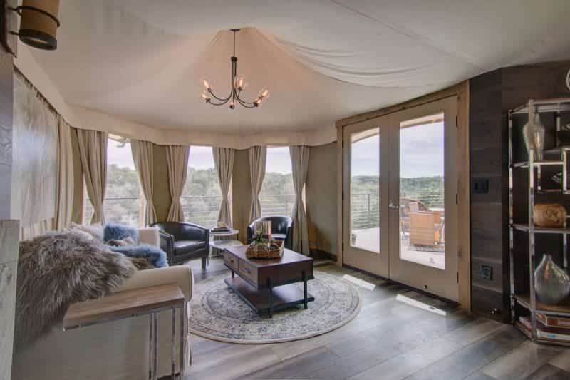 A living room with a couch , chairs , a coffee table and a chandelier.