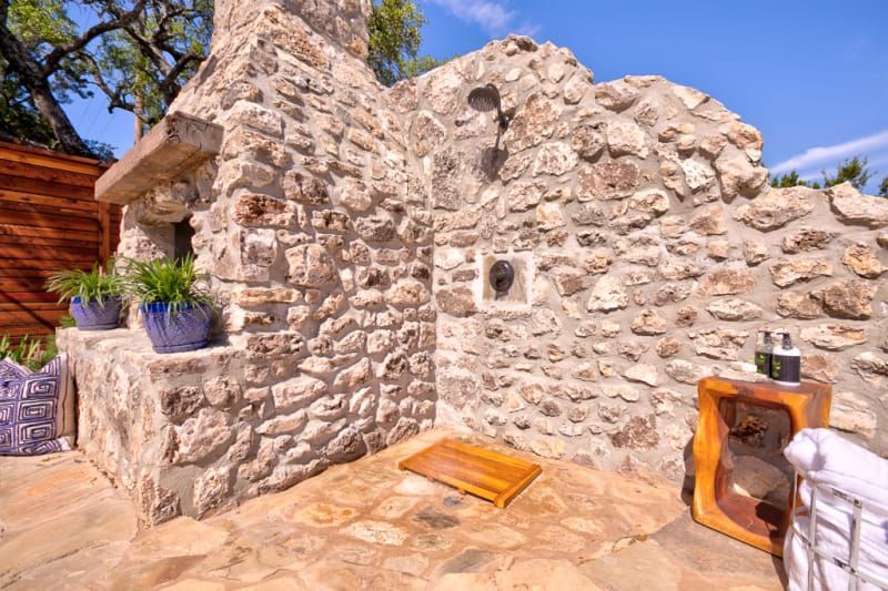 A stone wall with a wooden bench in front of it.