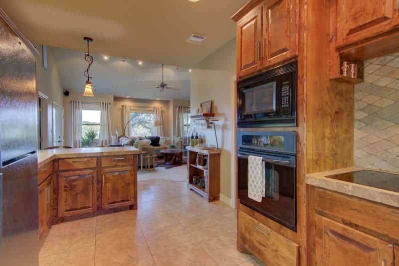 A kitchen with wooden cabinets , stainless steel appliances , and a microwave oven.