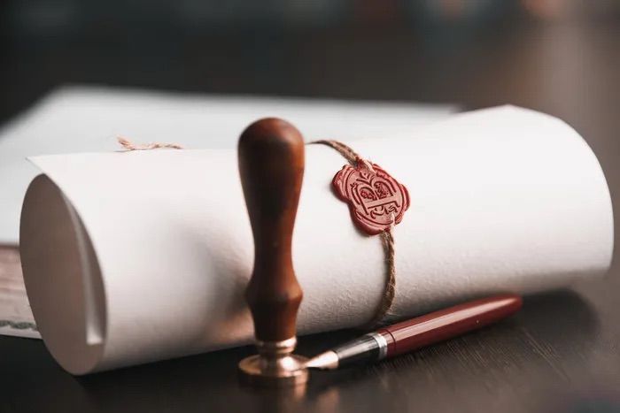 Parchemin roulé, ficelé et scellé à la cire, avec un stylo-plume et un tampon intégrés.