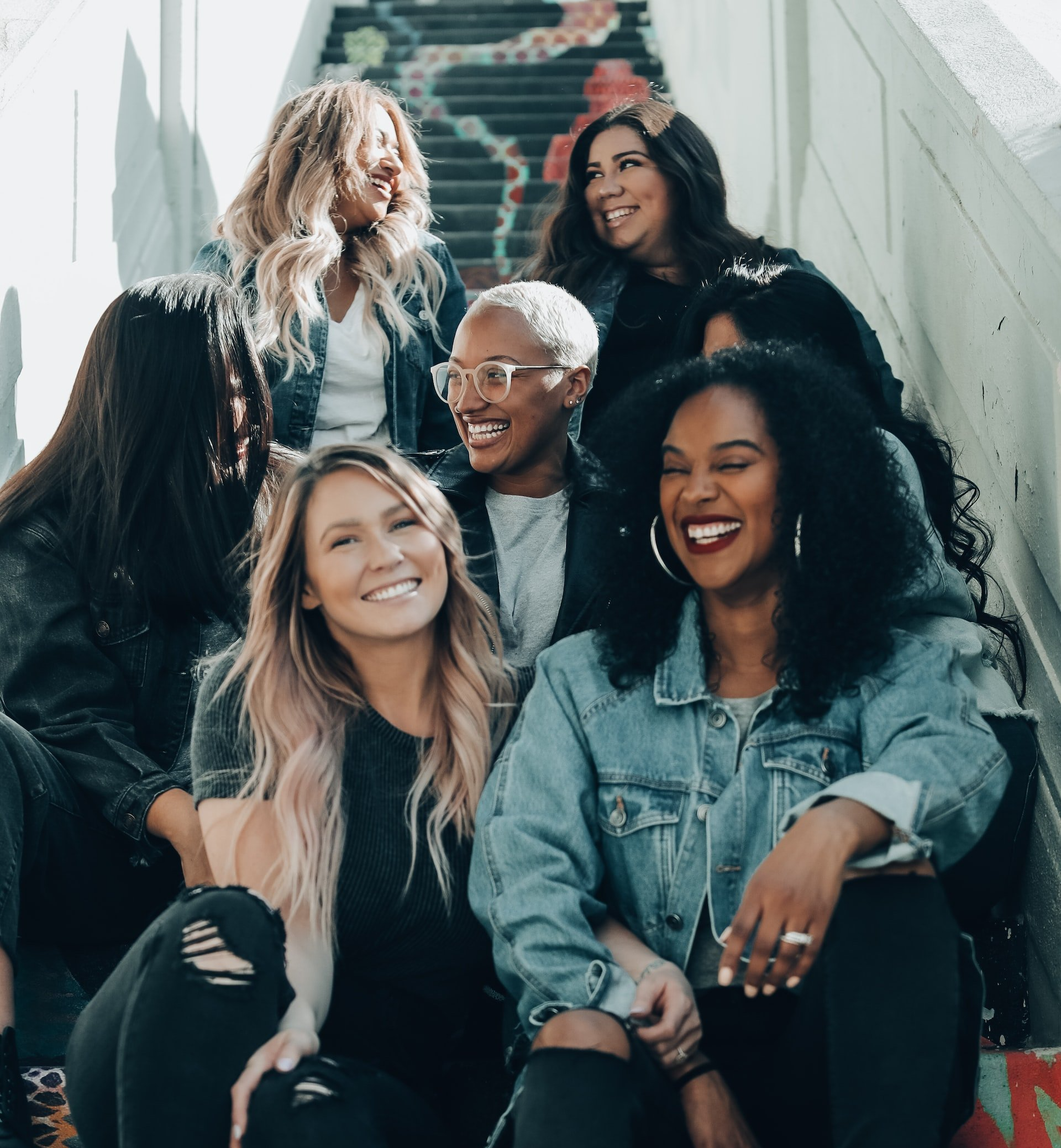 A group of women are posing for a picture on a set of stairs.blackbook backpack