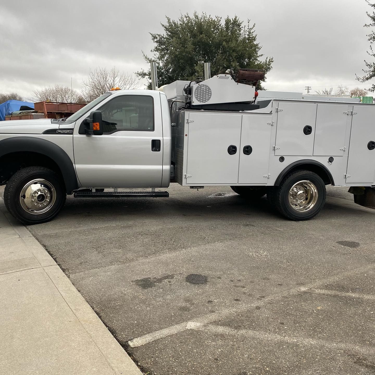 A white utility truck is parked in a parking lot