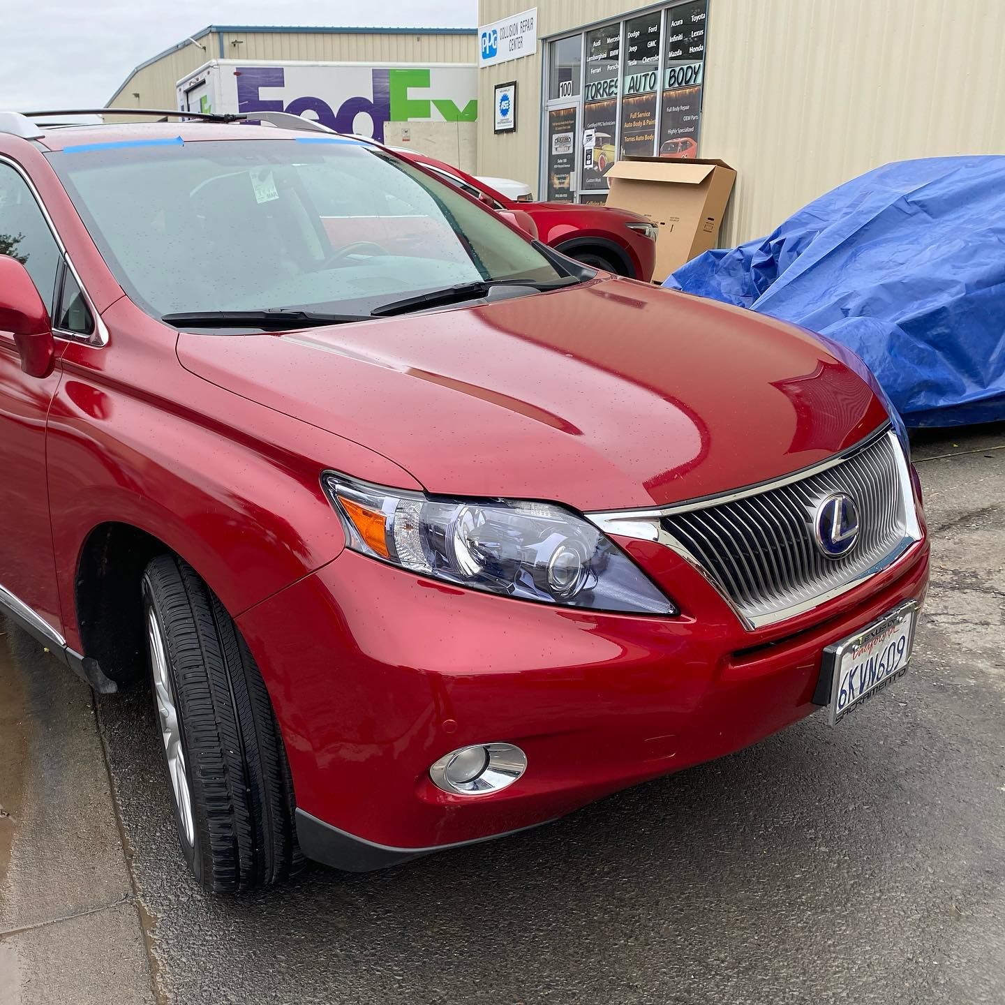 A red car is parked in front of a fedex building
