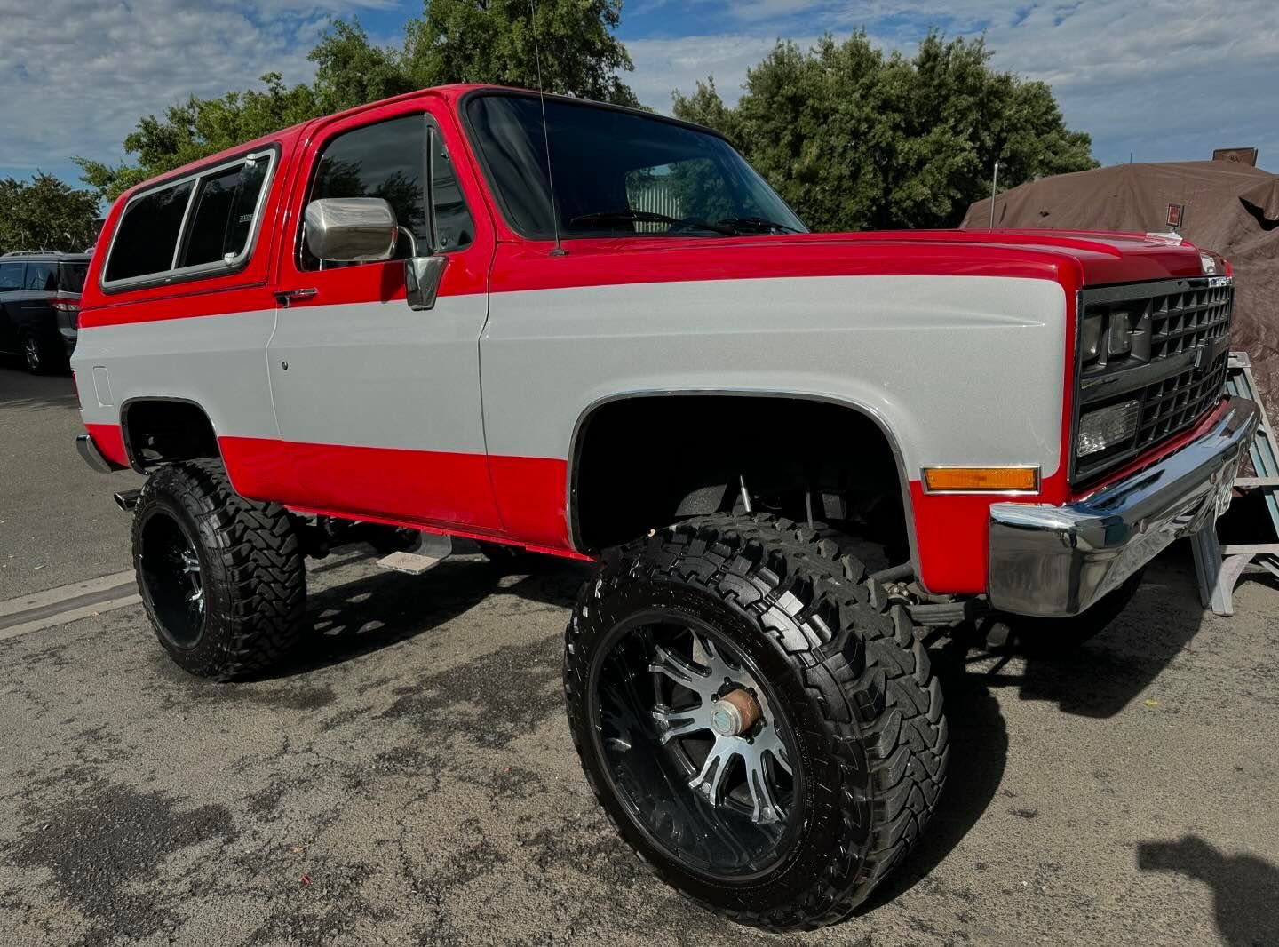 A red and white truck is parked in a parking lot.