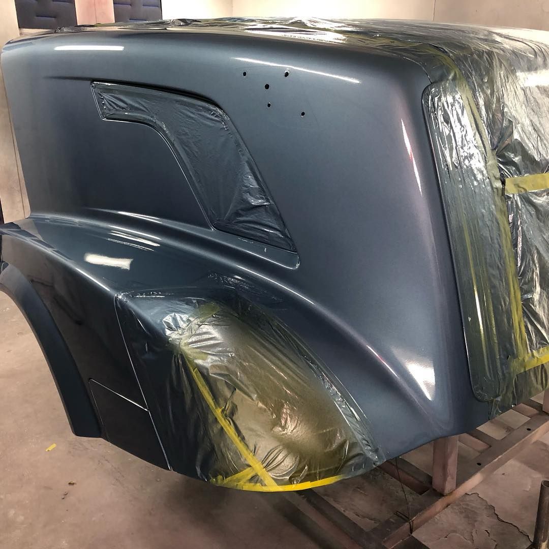A truck hood is wrapped in plastic and sitting on a table.