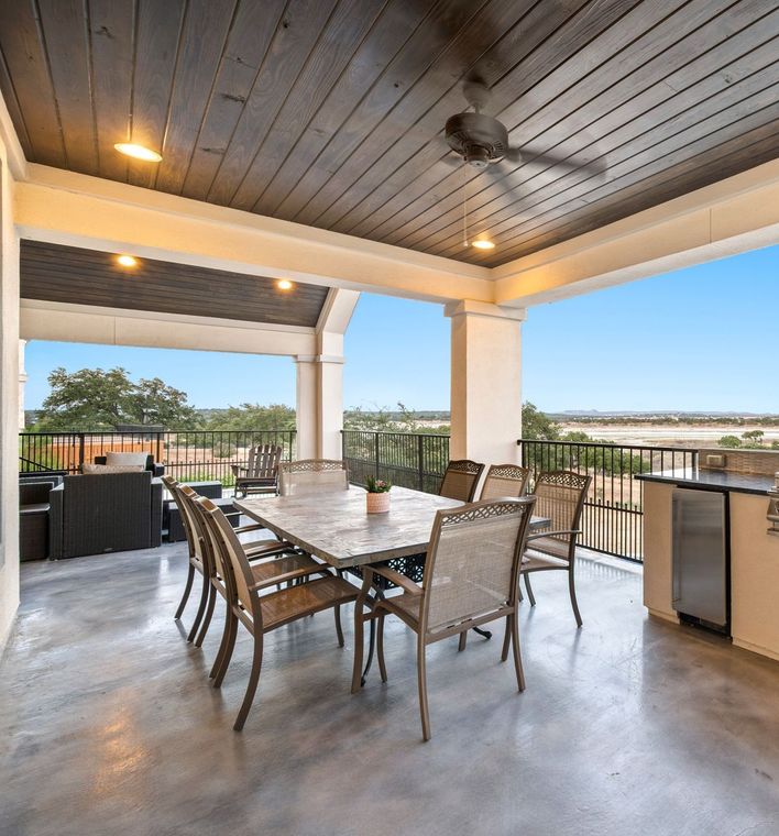 A patio with a table and chairs and a ceiling fan.