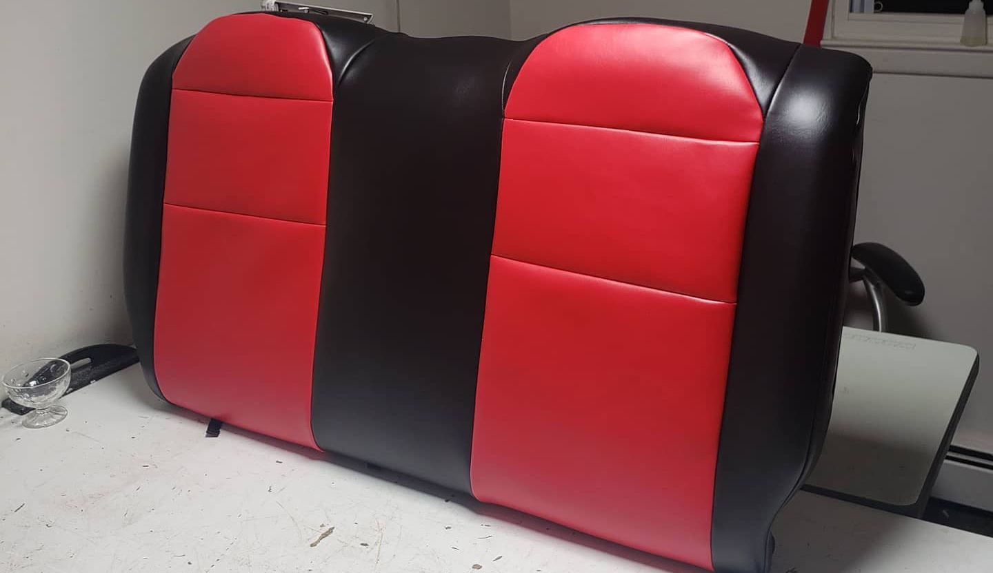 A red and black car seat is sitting on a table A red and black car seat is sitting on a table