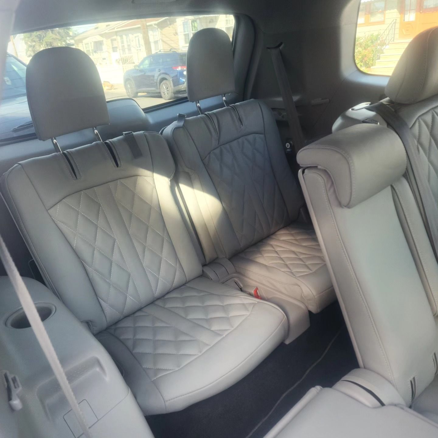 The back seat of a car has a seat belt on it