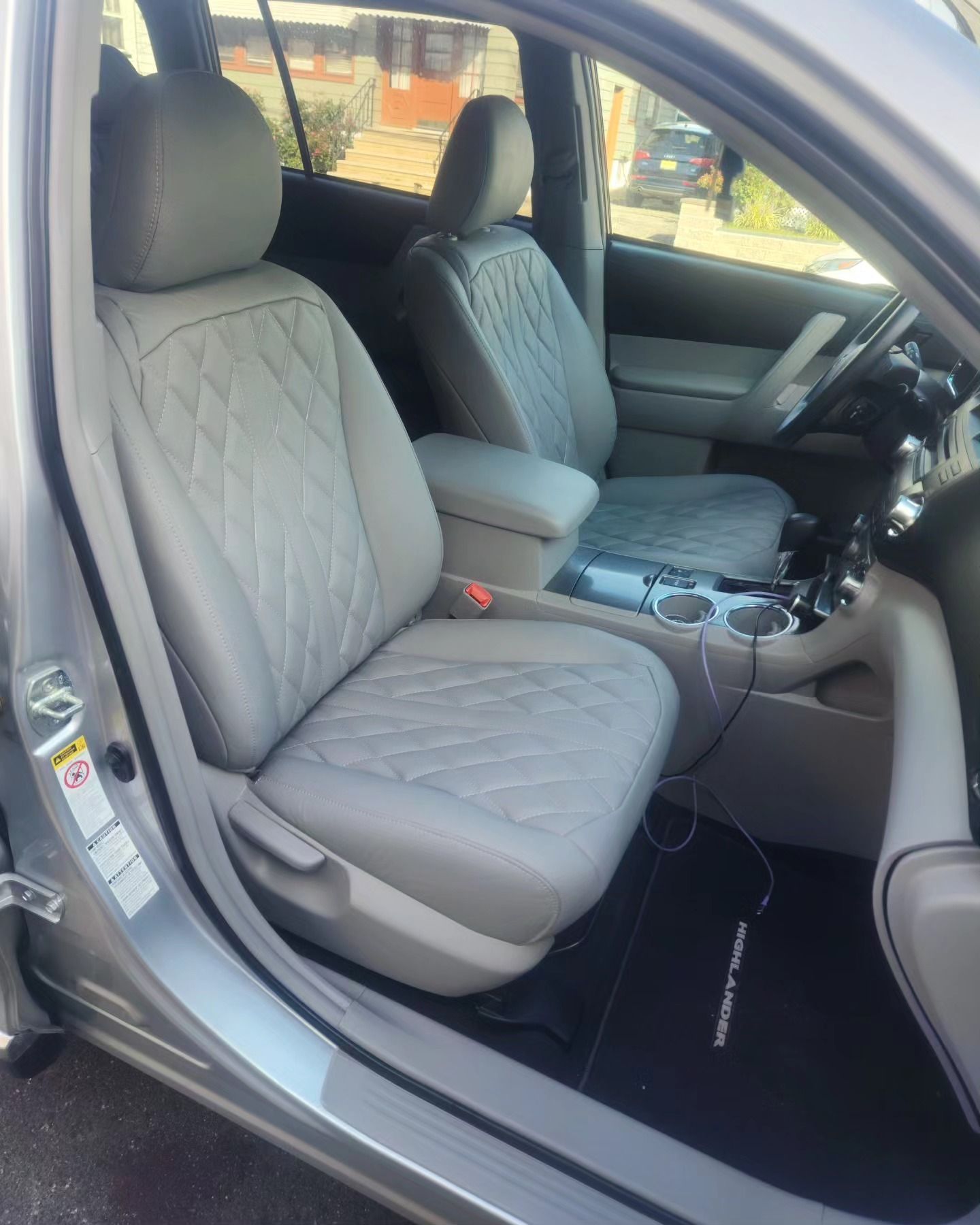 The interior of a silver car with gray seat covers