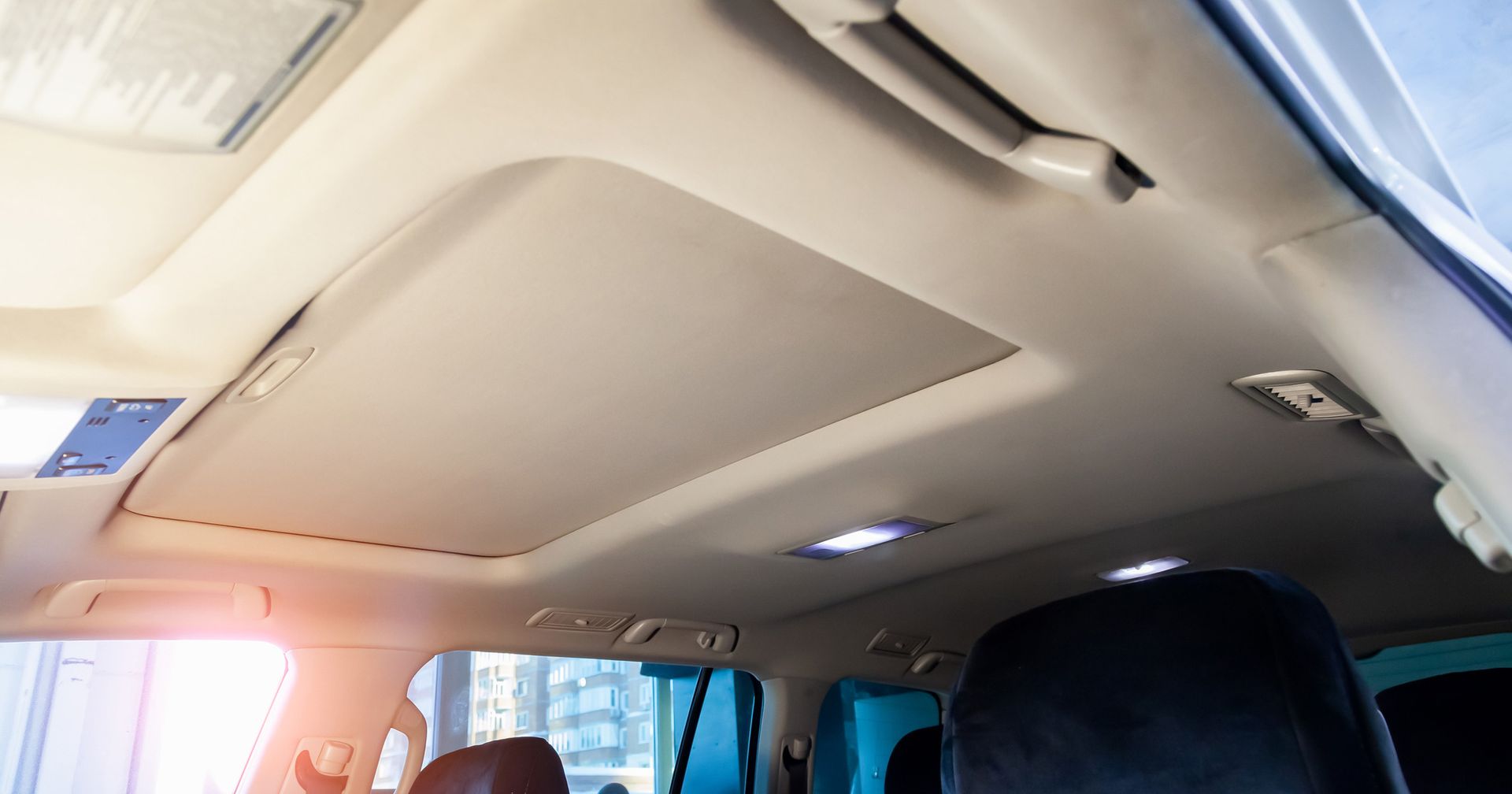 The ceiling of a car with a sunroof. The ceiling of a car with a sunroof.