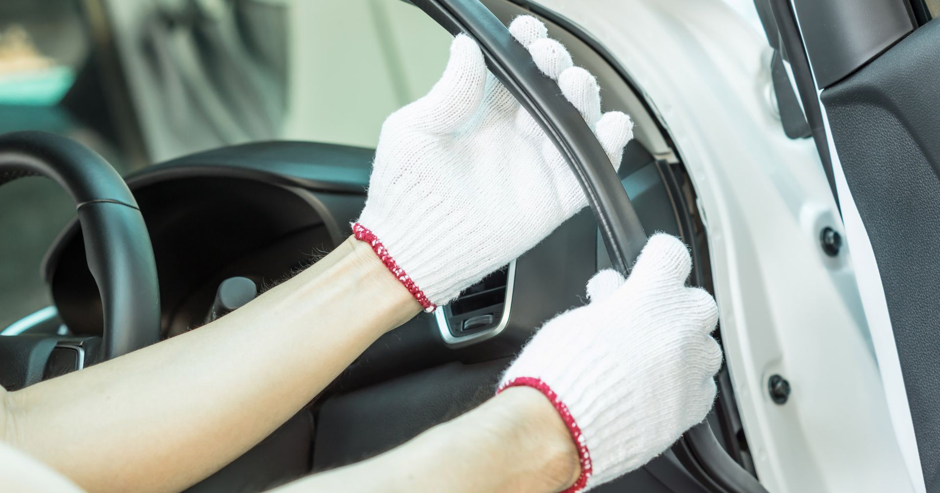 A person wearing white gloves is opening the door of a car. A person wearing white gloves is opening the door of a car.