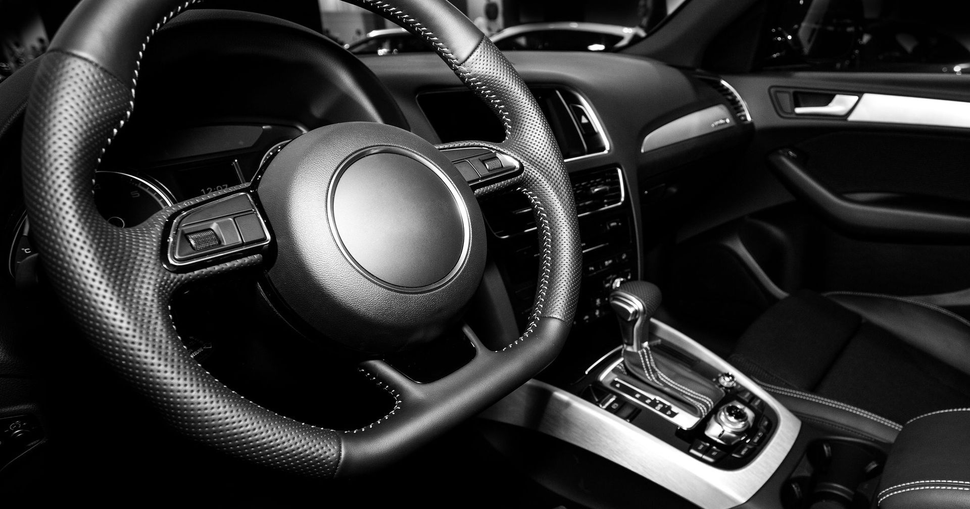 An interior of a car with a steering wheel. An interior of a car with a steering wheel.