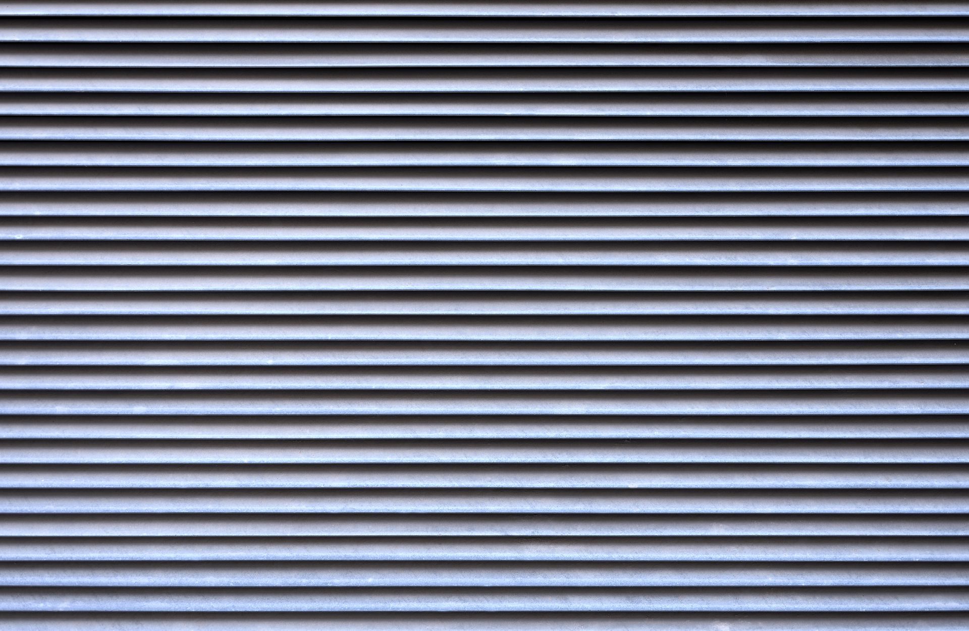 Lamelles d'aération horizontales en métal gris.