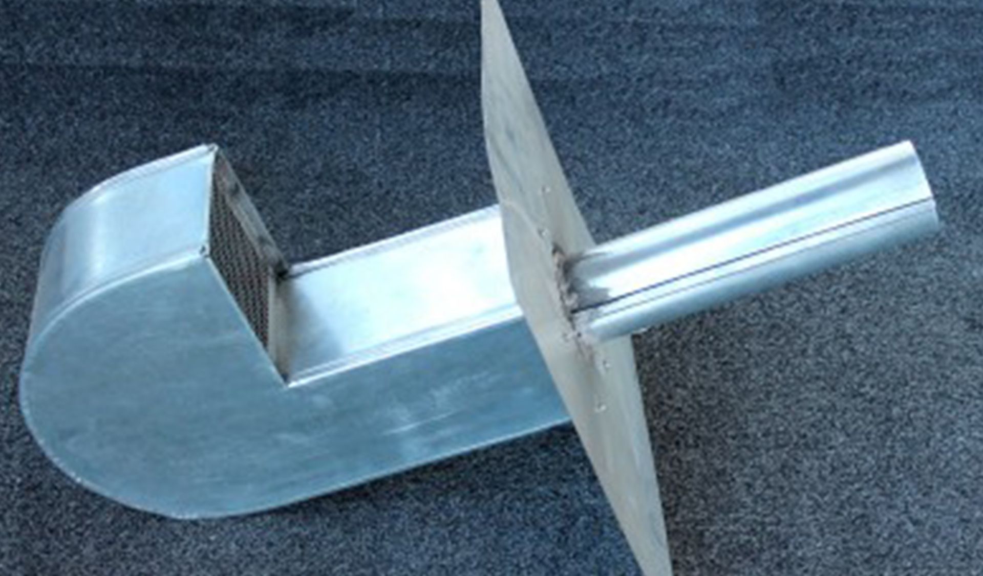 Vue extérieure à travers les stores ouverts : ciel bleu, arbres et bâtiments visibles.