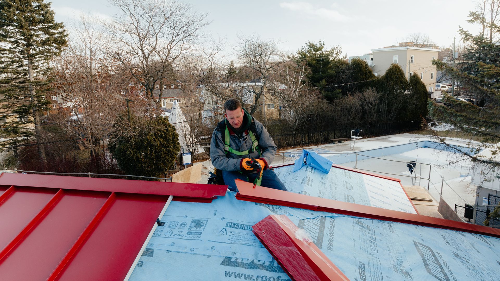 Un homme travaille sur le toit d'une maison.