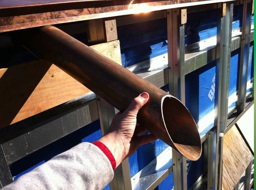 Une personne tient un tuyau en cuivre à la main