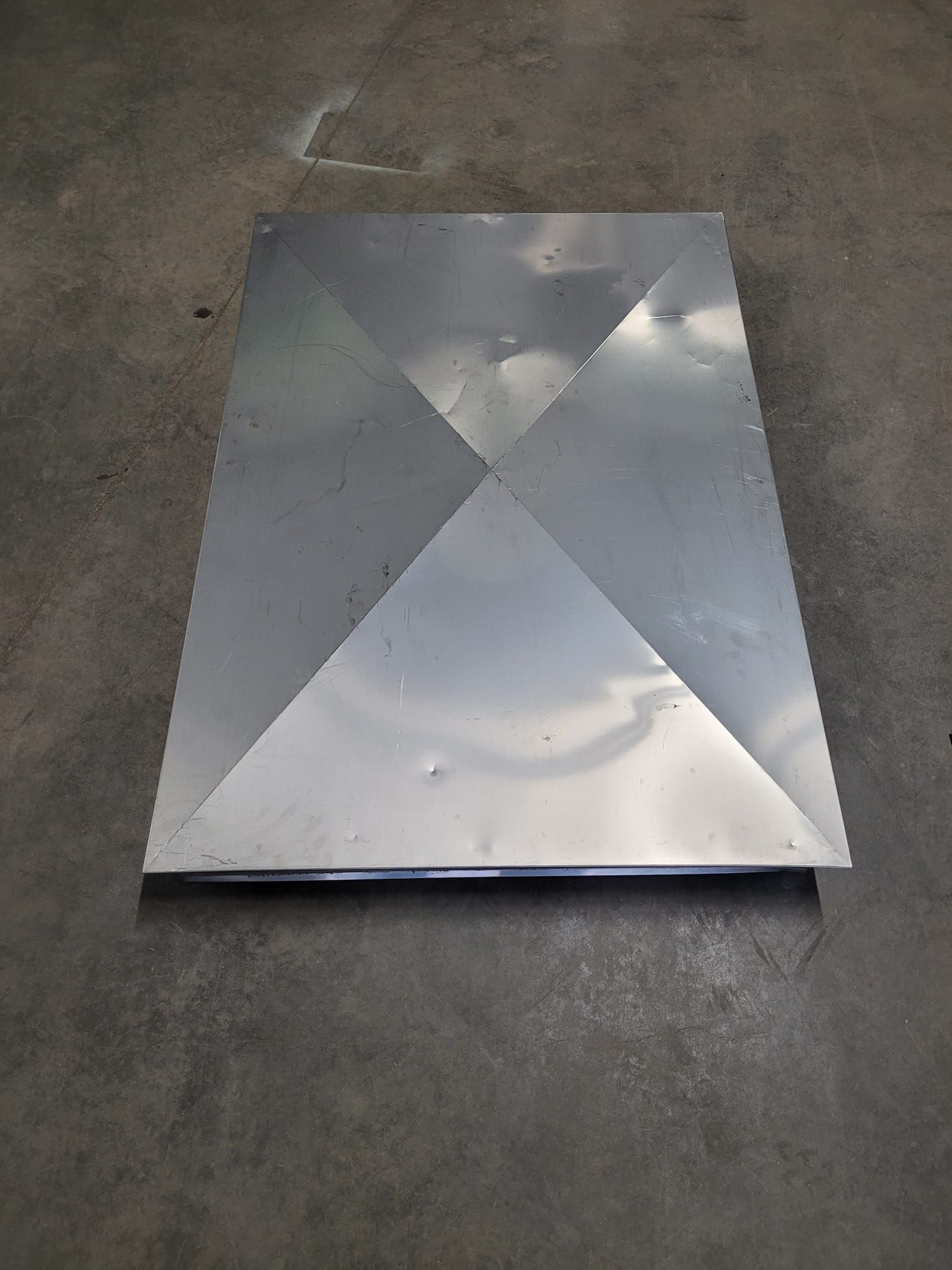 Un morceau de métal est posé sur un sol en béton.