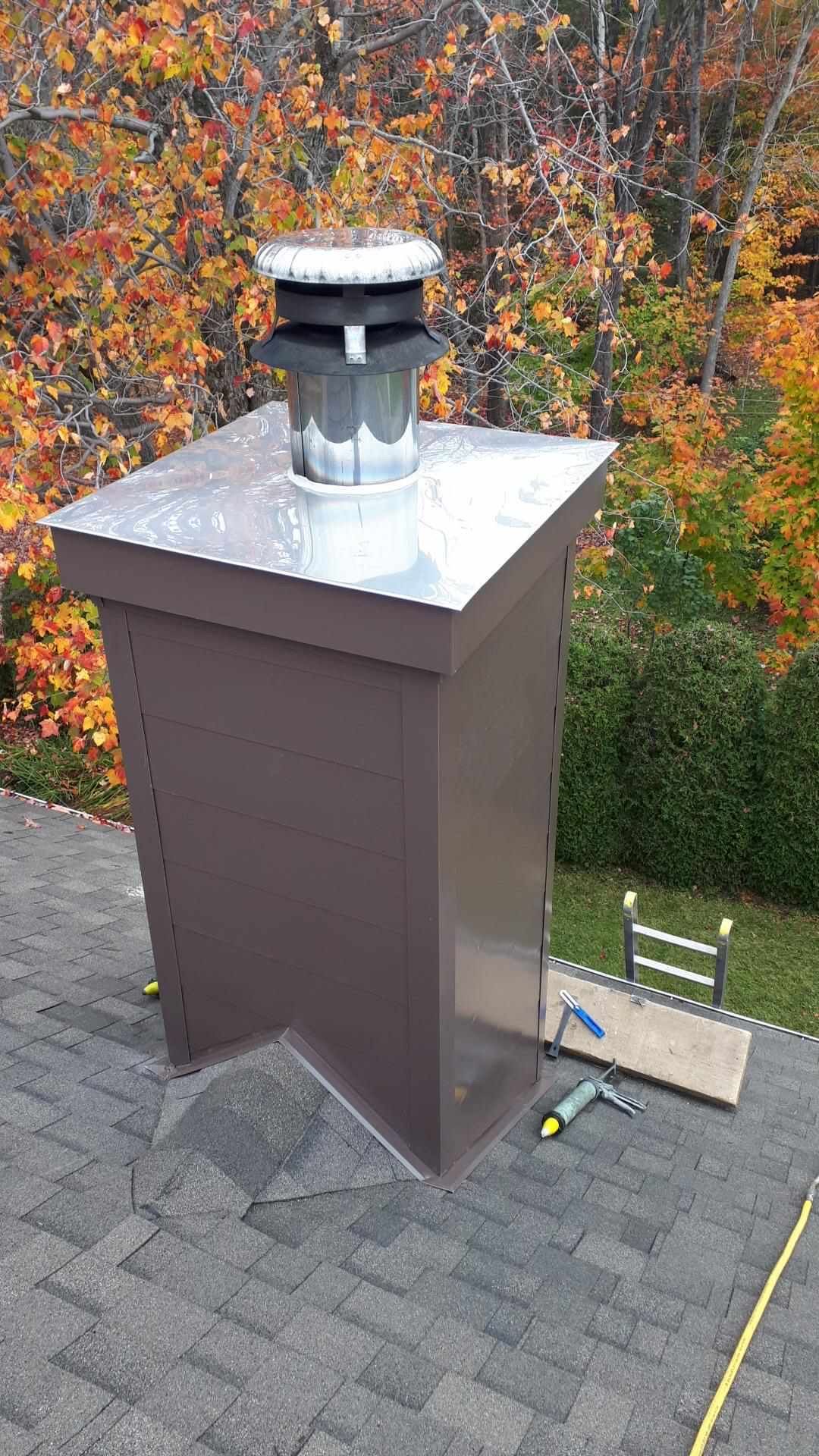 Une cheminée est posée au sommet d'un toit en brique.