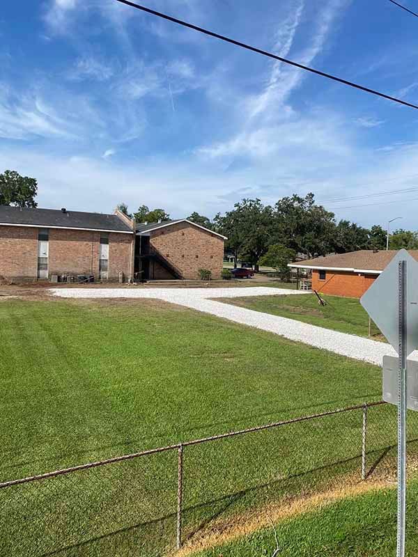 A fenced in yard with a house in the background and a sign in the foreground.