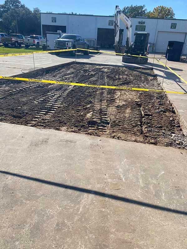 A construction site with a bulldozer and a building in the background.