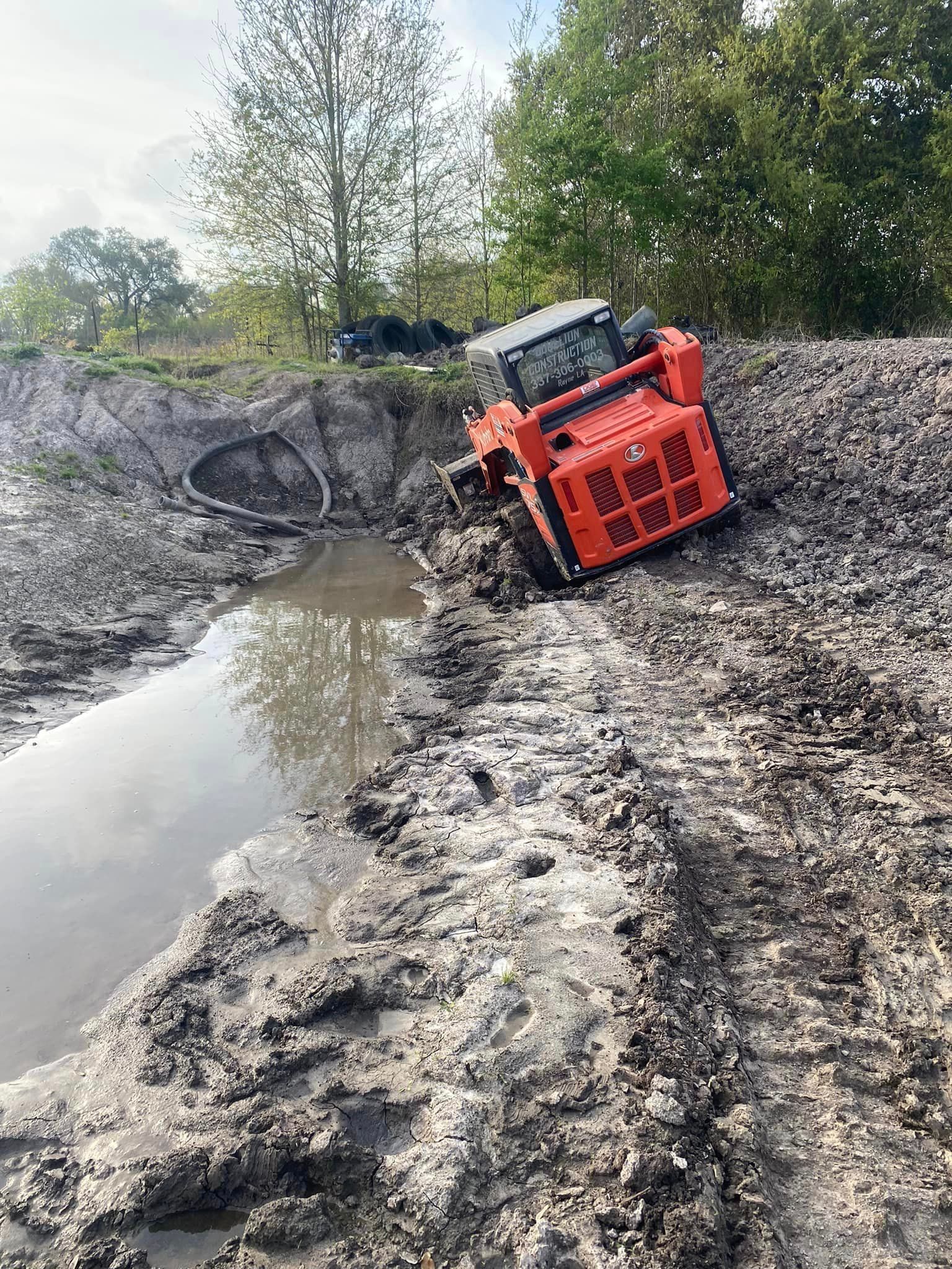 A bulldozer is stuck in the mud on a muddy road.