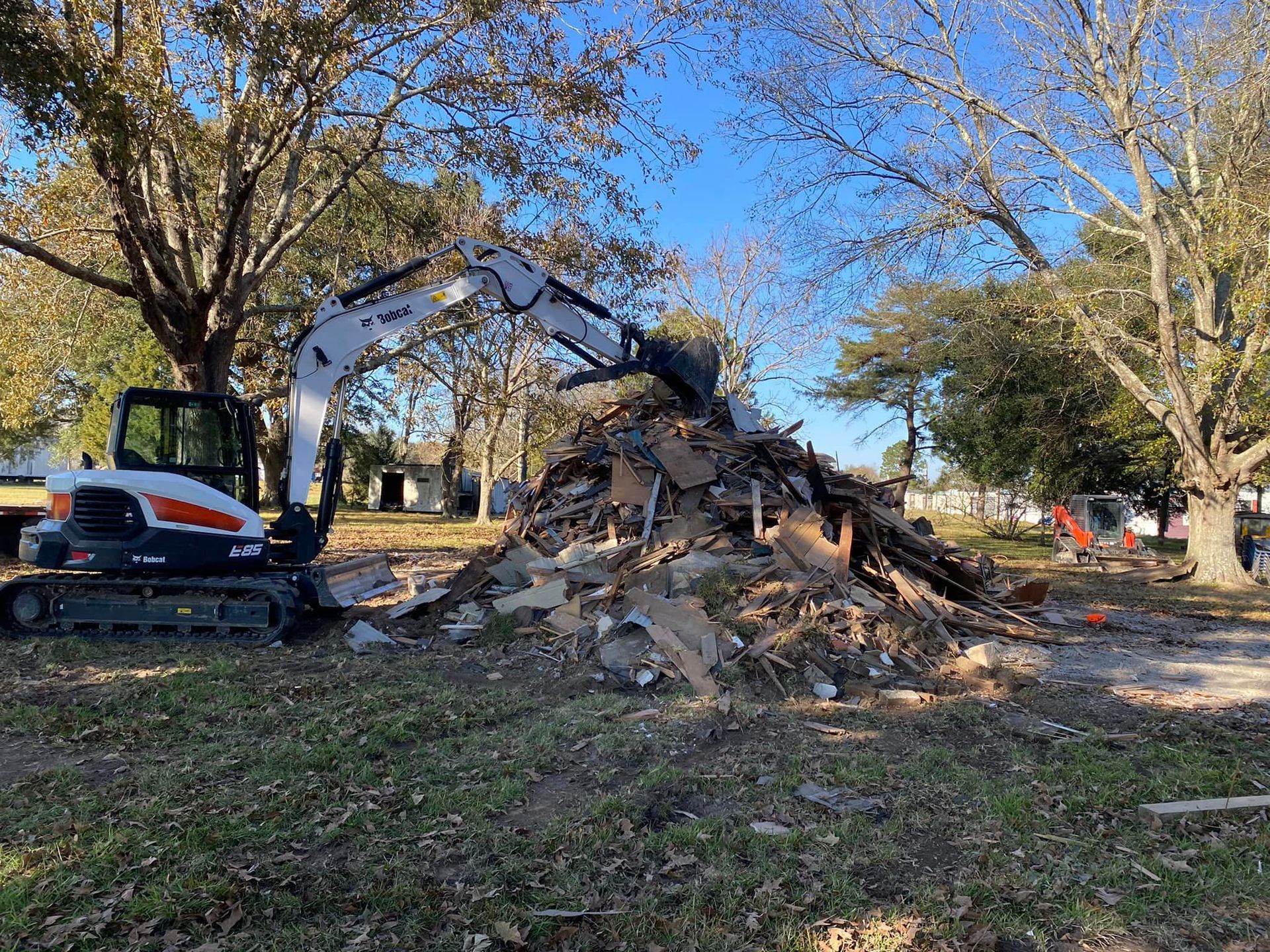 A bulldozer is demolishing a building in a park.