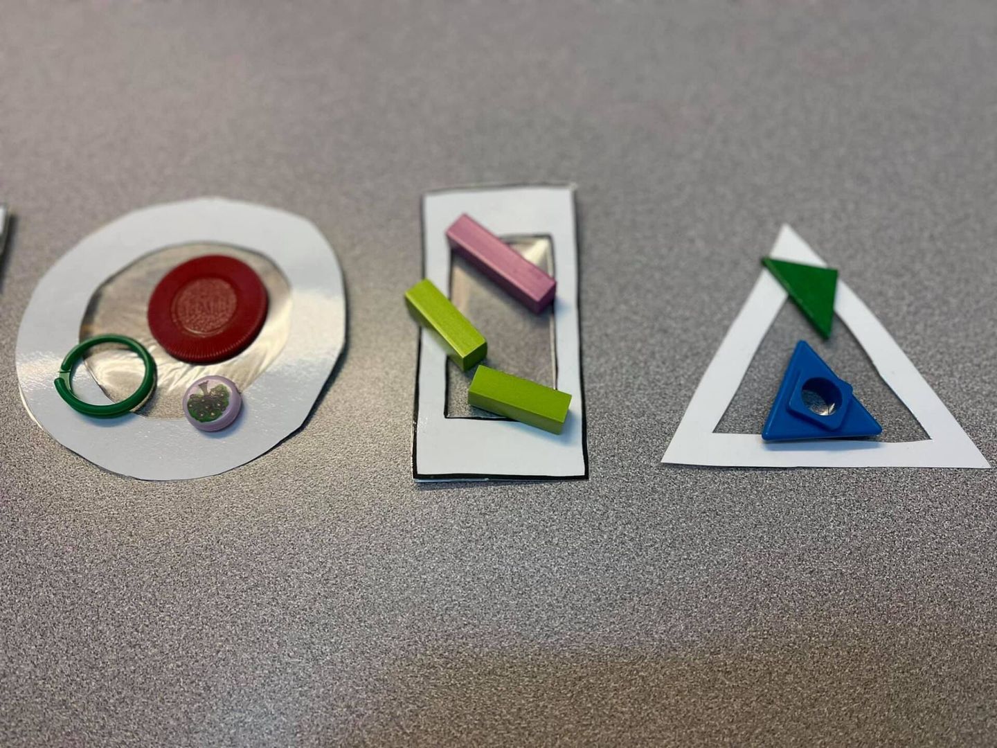 Three geometric shapes with various colored objects inside