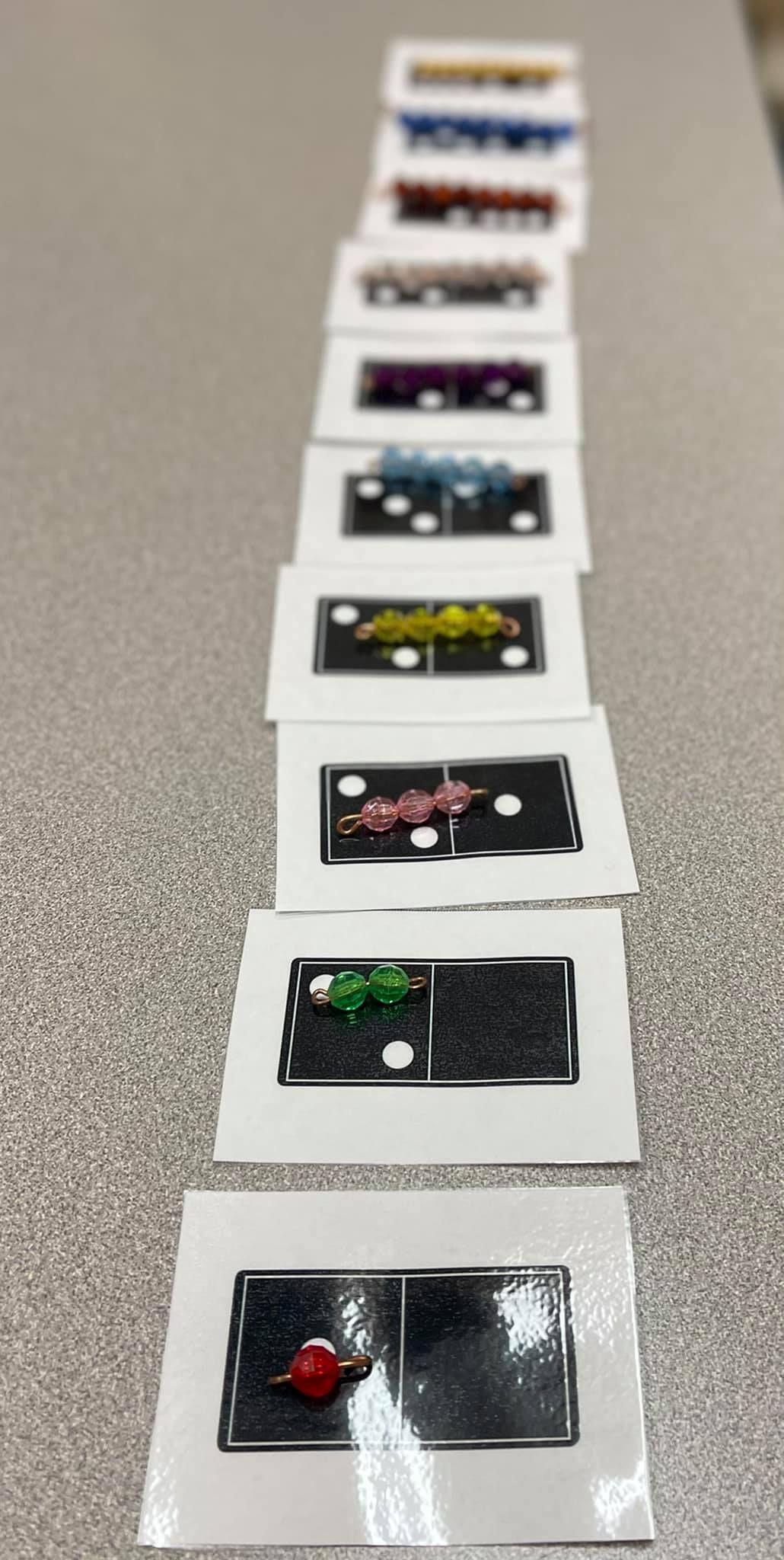 Row of dominoes, each with different colors, arranged on a surface
