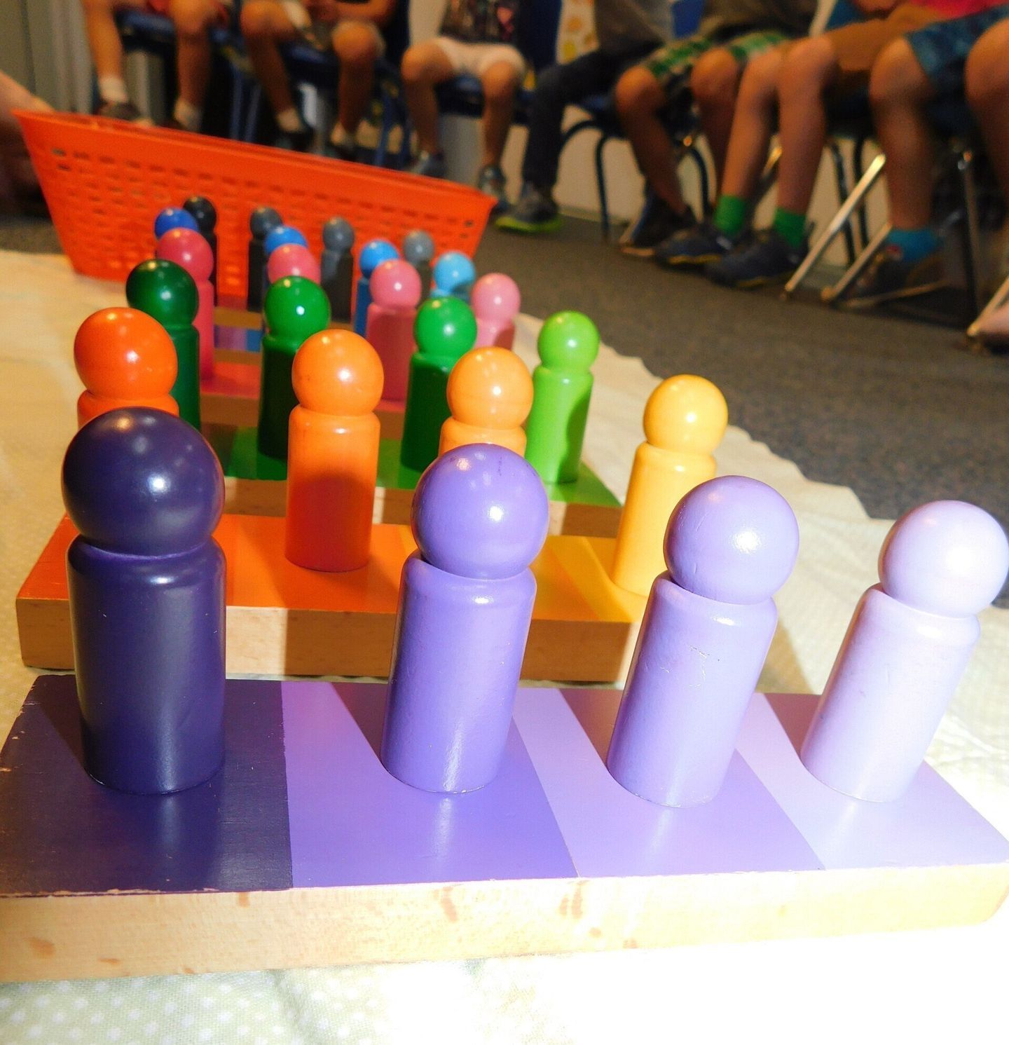 Colorful pegboard game with children in the background