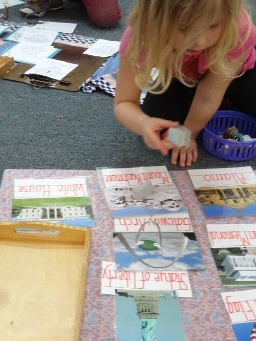 Young girl sorting objects with flashcards of landmarks