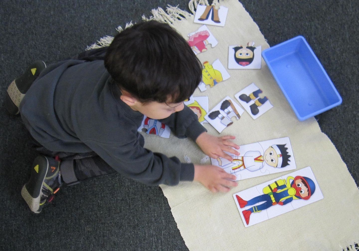 Young child playing with picture cards on a rug