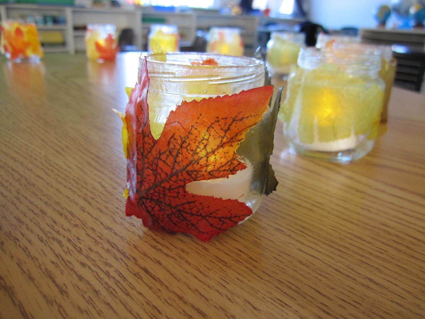 Autumn-themed glass jars with leaf decorations