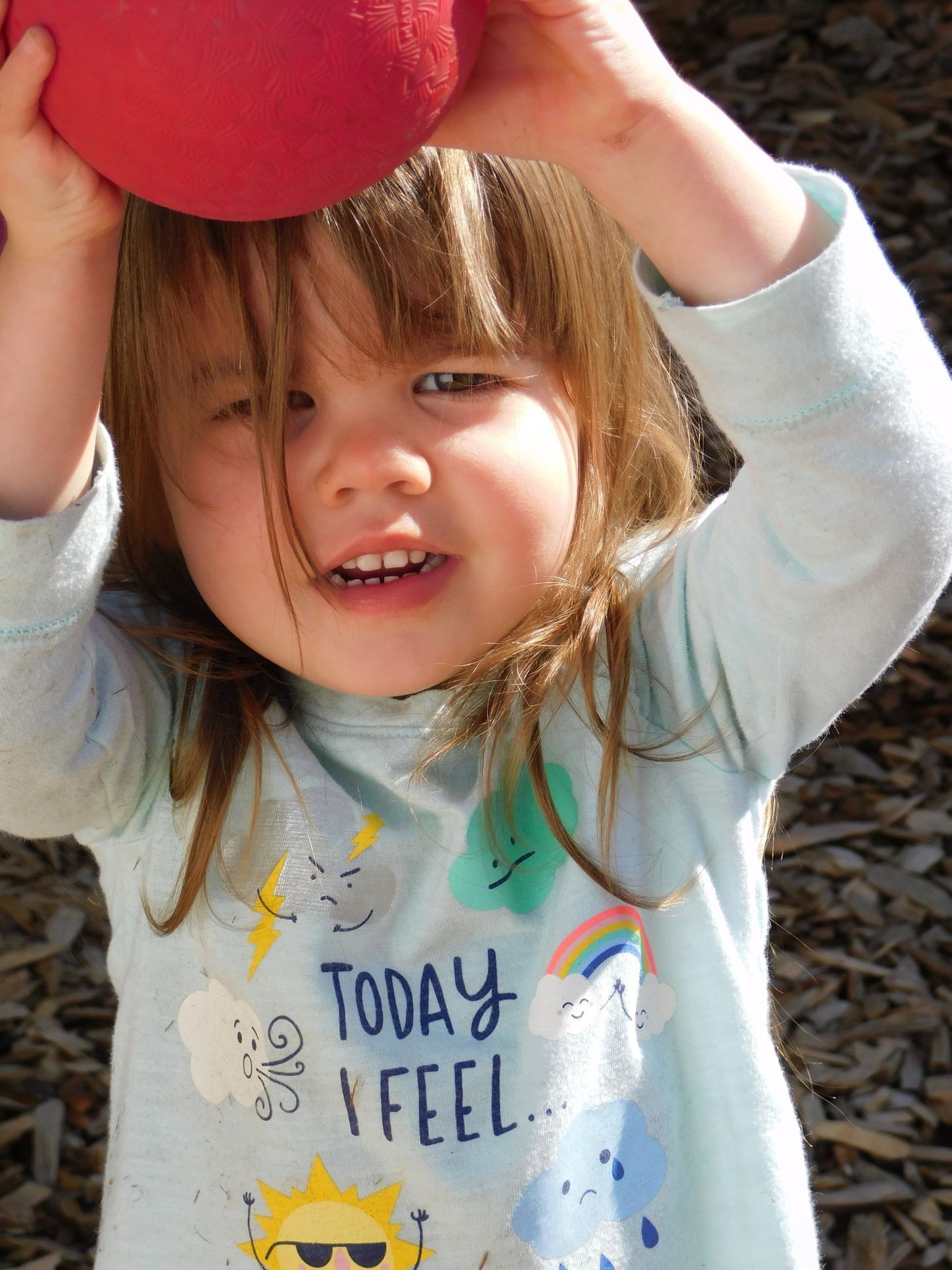 Child holding red ball