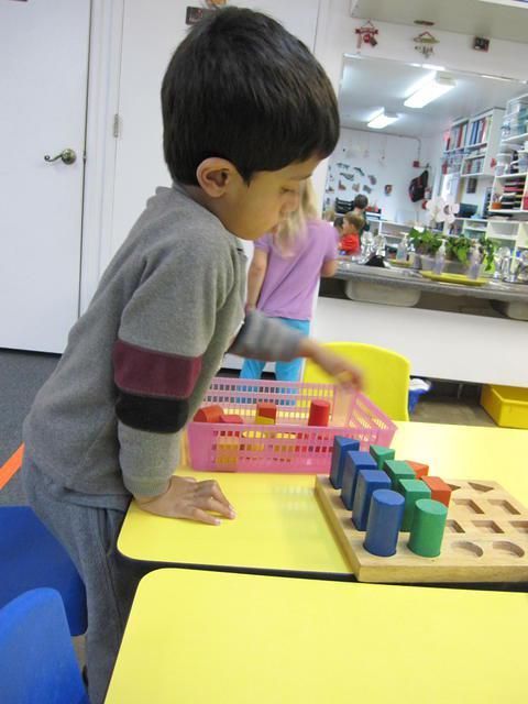 A boy playing with wooden blocks in a classroom