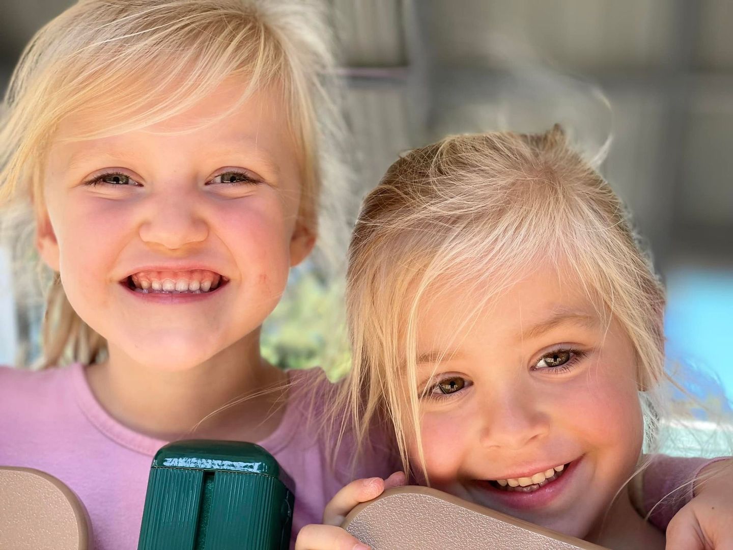 Two blonde girls smiling at camera