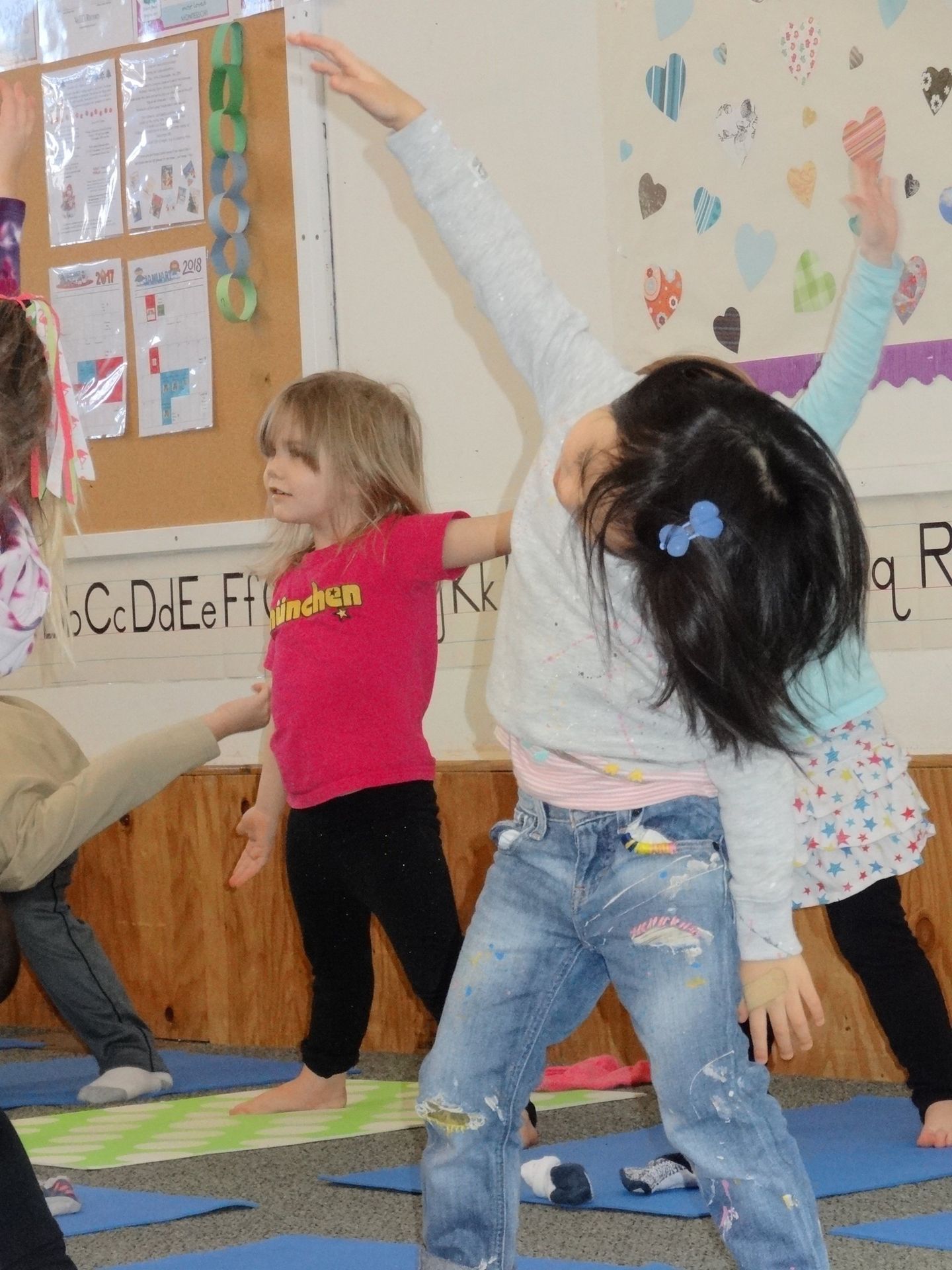 Children in a classroom doing yoga