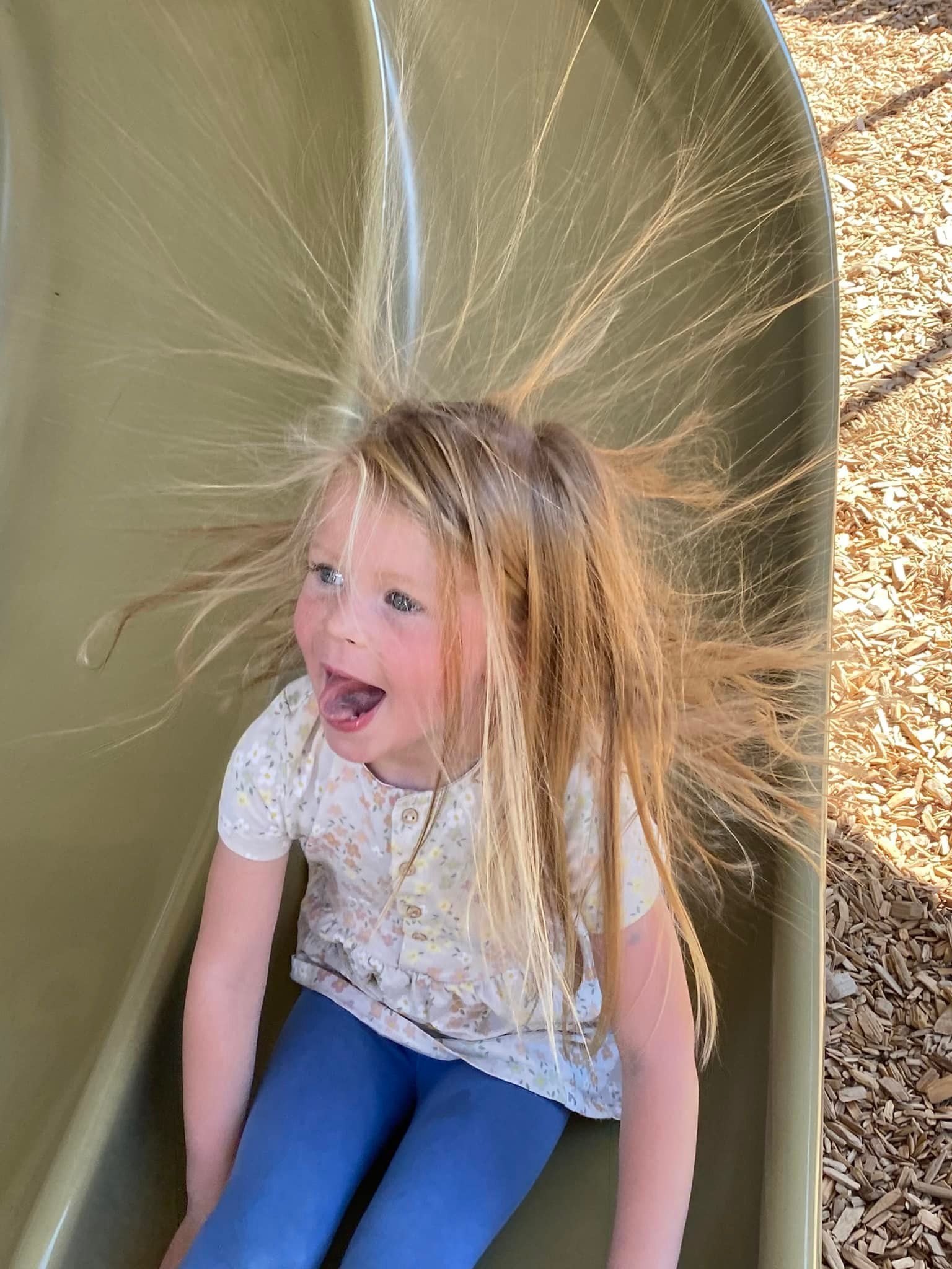 Girl with blond hair standing on slide