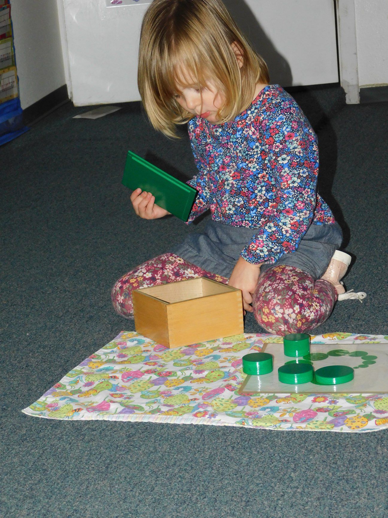 A young girl kneels on the floor