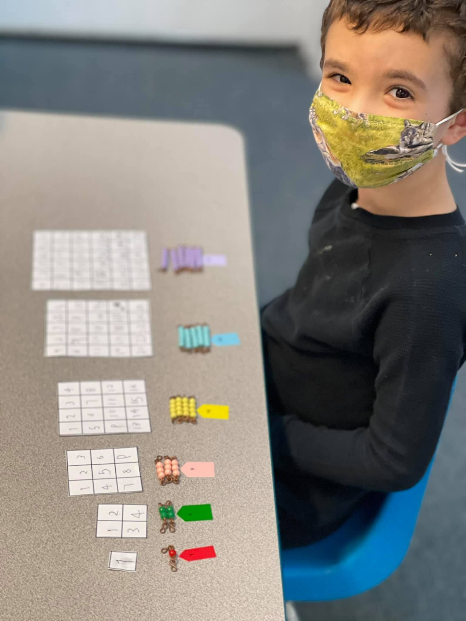 Boy with a mask smiles at the camera