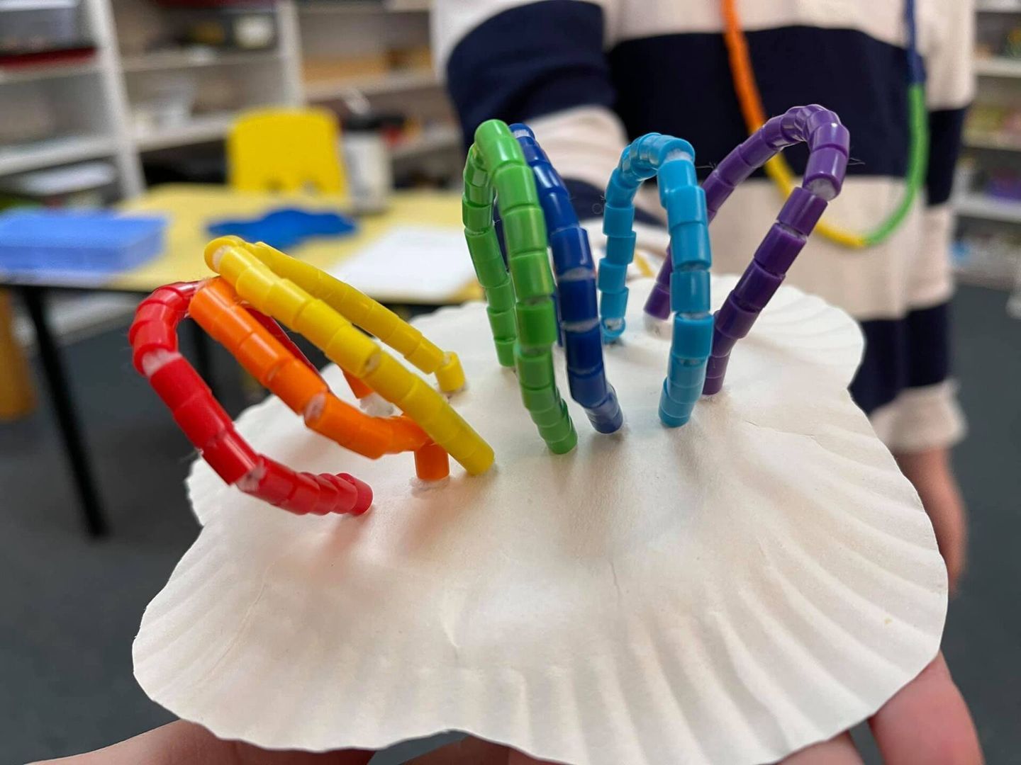 A hand holding a white seashell 