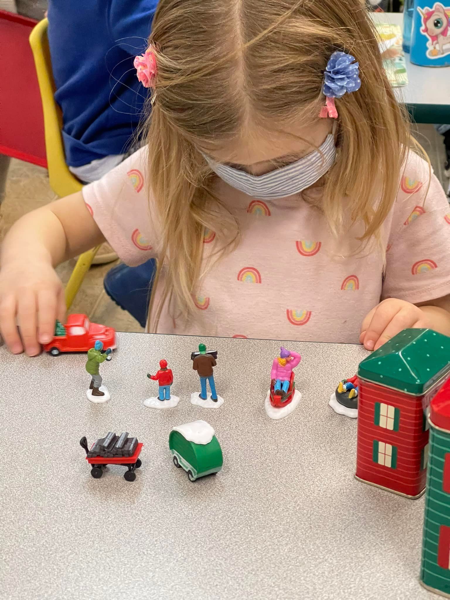 Girl in mask plays with miniature
